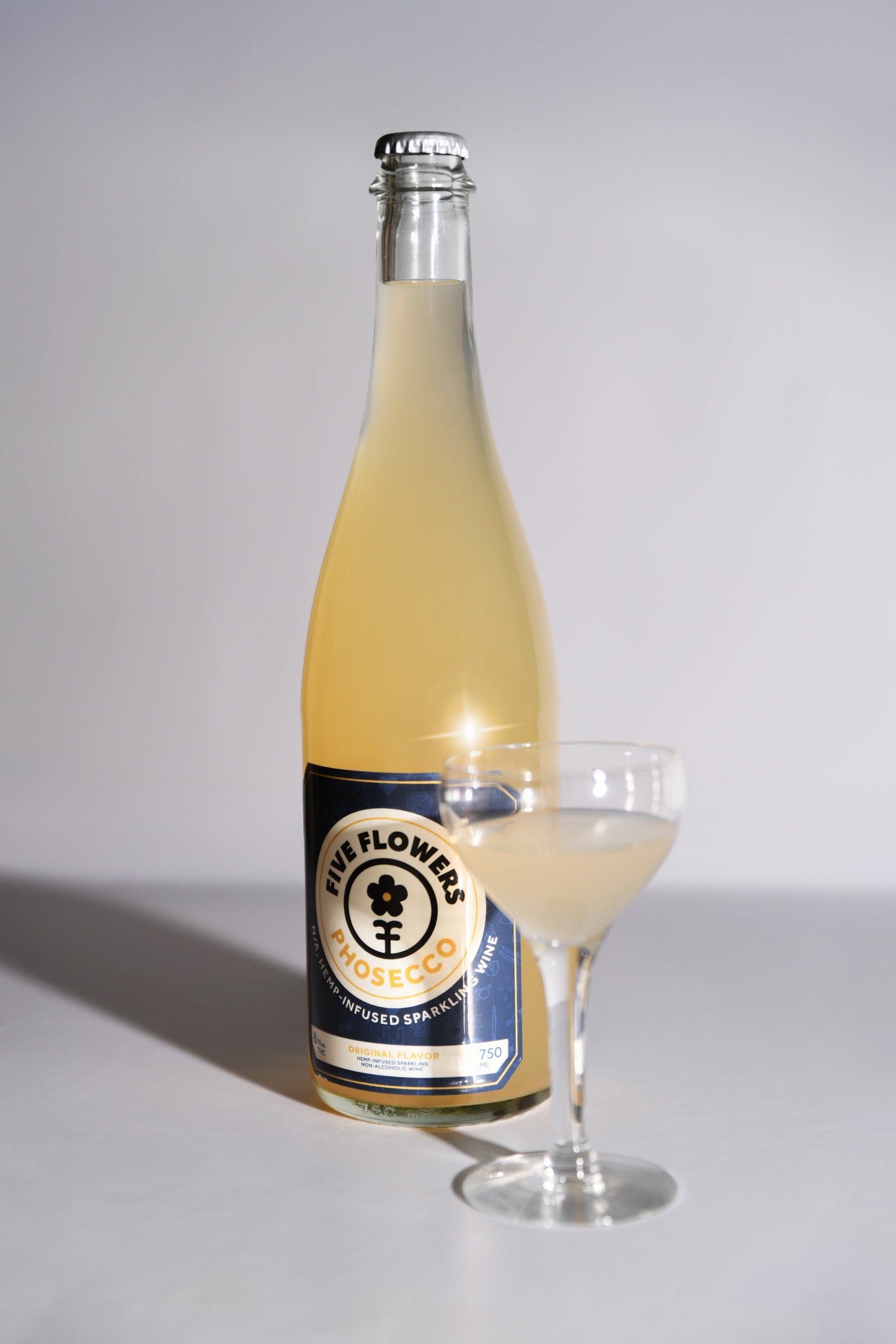 Bottle and glass of a beverage with a label on a white background